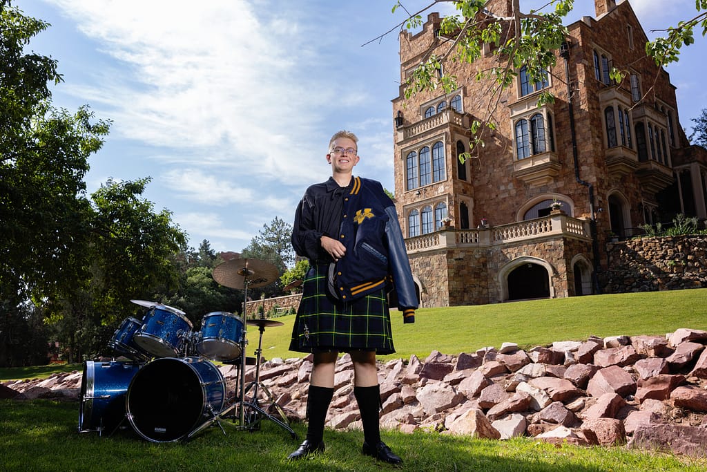 Male senior portrait Glen Eyrie Castle Colorado Springs letter jacket drums kilt The Vanguard School