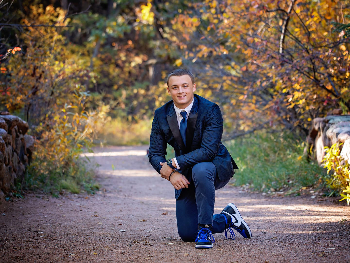 male senior portrait in woods fall